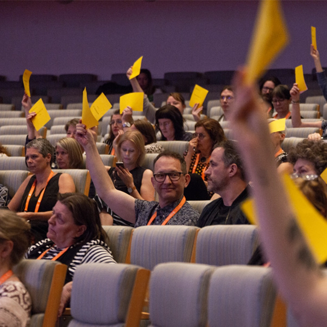Flera personer som räcker upp handen.