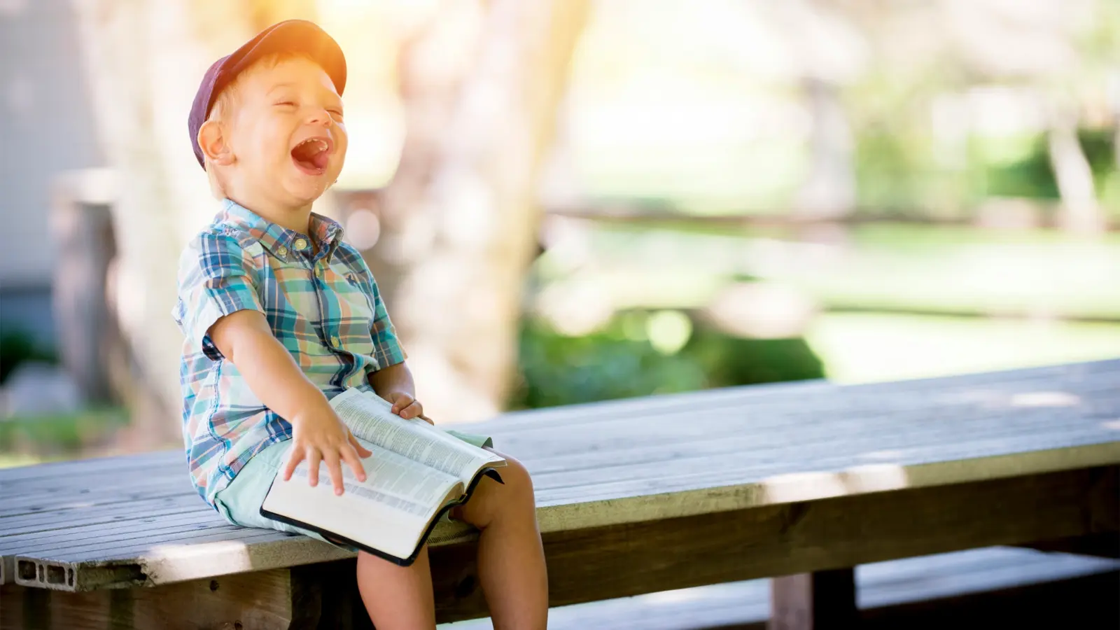 Barn som skrattar och läser en bok.