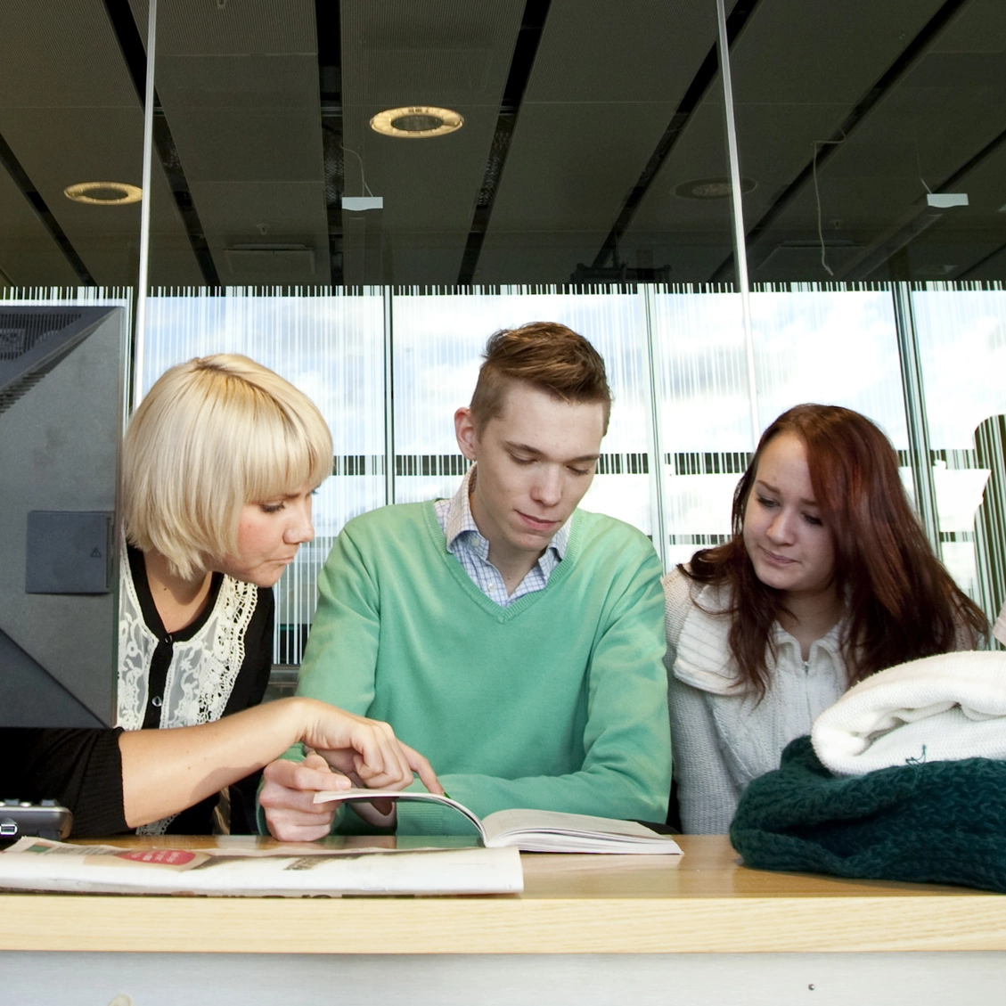 Bild på tre studenter vid ett bord.