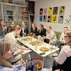 Ett tiotal personer runt bord med bubbel och snittar.